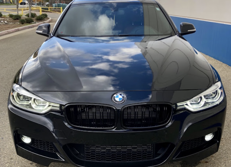Detailed black BMW sedan with mirror-like glossy paint