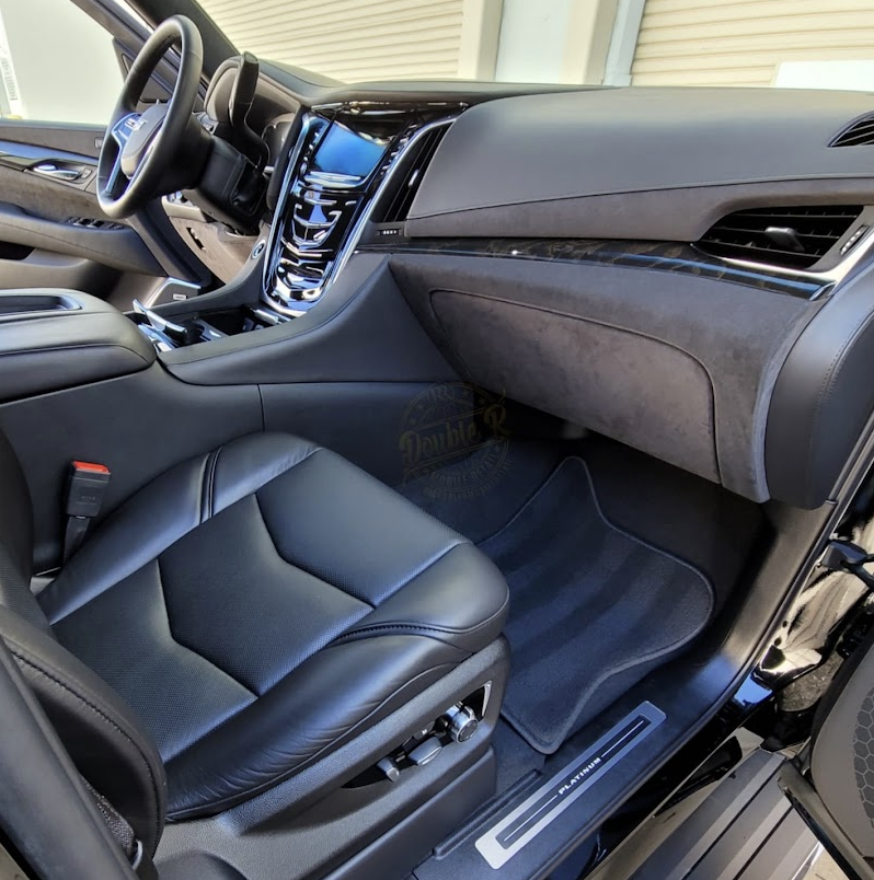 Detailed black leather interior and floor mats of a Cadillac Escalade
