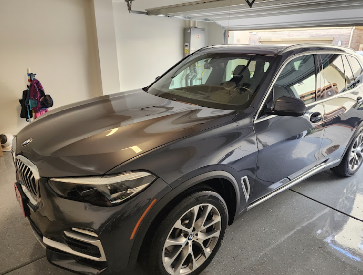 Detailed BMW X5 SUV with deep paint gloss in a garage